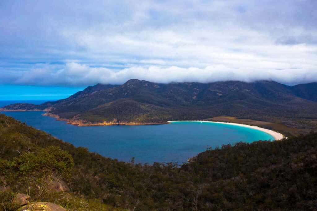 冬季塔斯马尼亚酒杯湾全景,碧蓝海水与森林山丘交相辉映